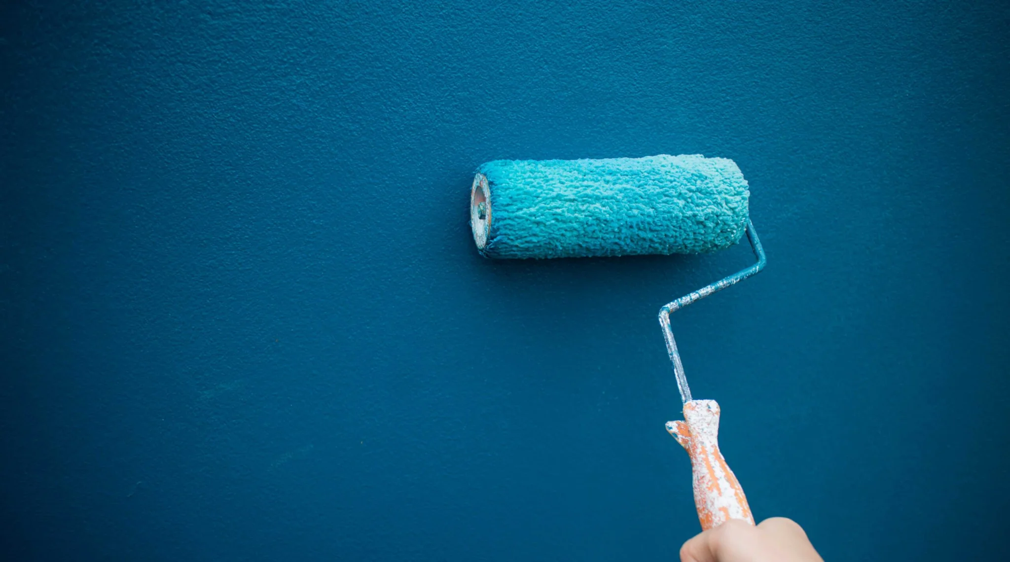 Parede pintada de azul com rolo de tinta