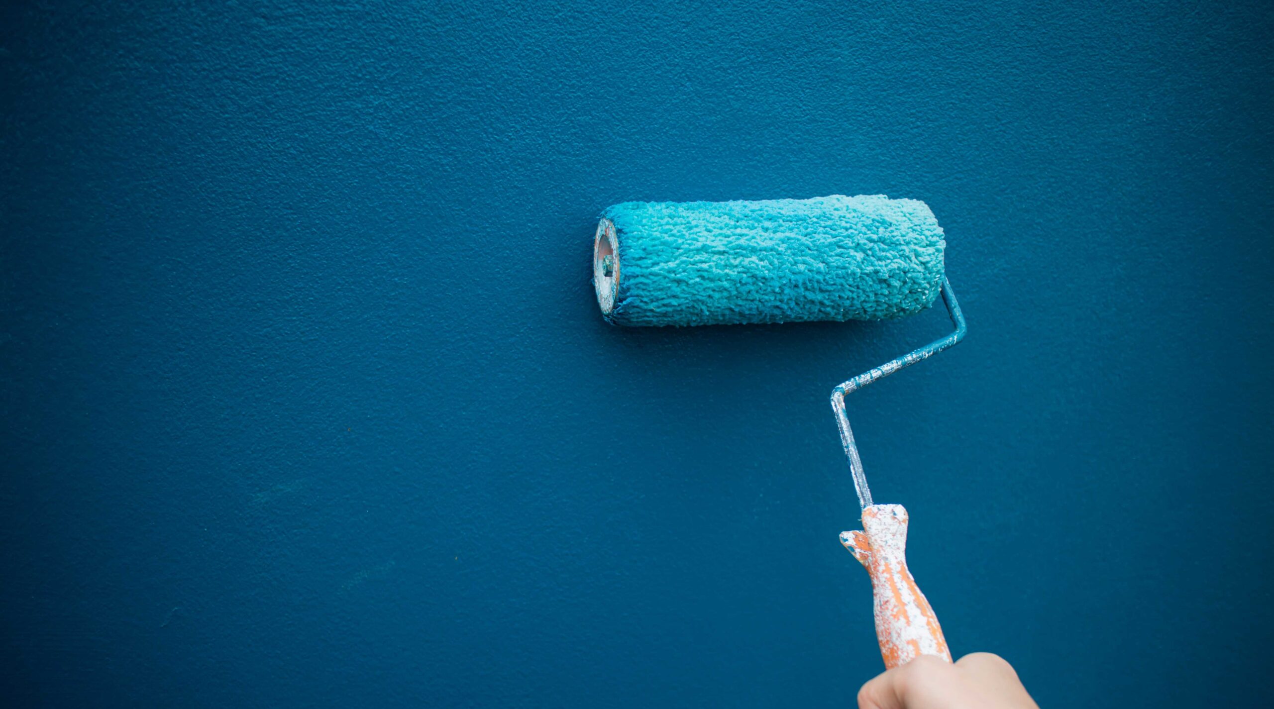 Parede pintada de azul com rolo de tinta